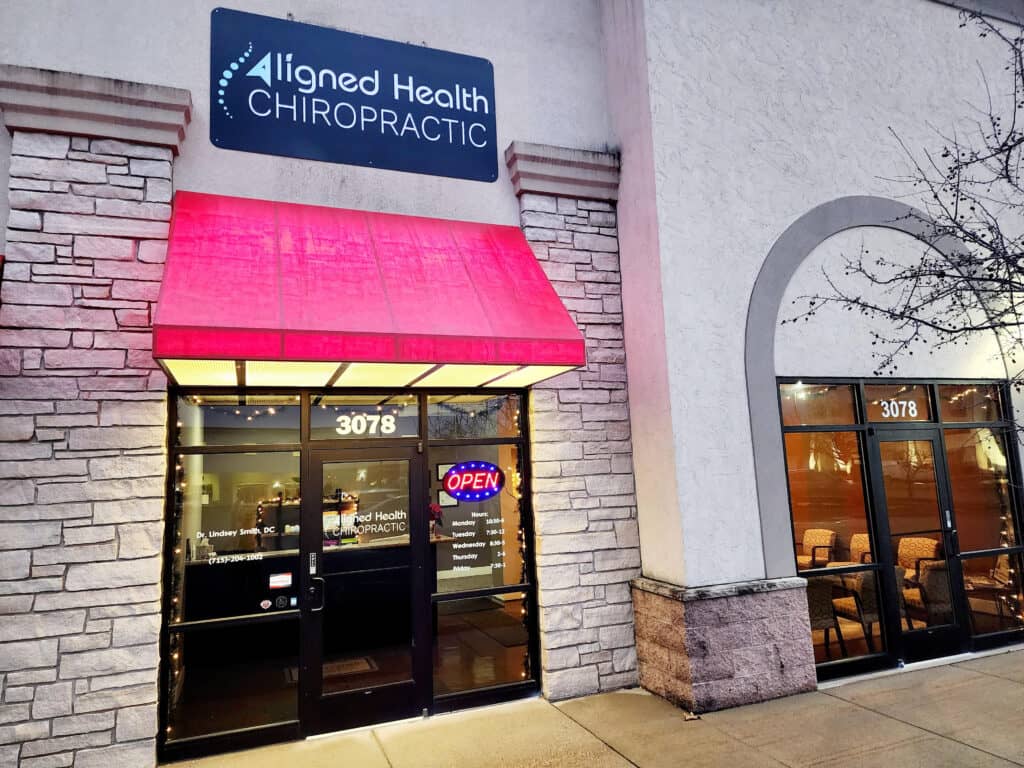 A business with a red awning and a sign that says "Aligned Health Chiropractic."