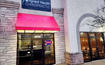 A business with a red awning and a sign that says "Aligned Health Chiropractic."
