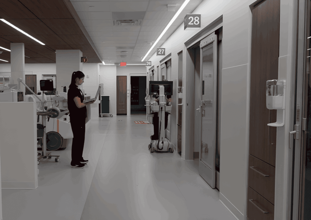 A woman standing in a hospital hallway.