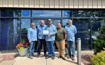 Five men standing in front of a building holding a certificate.