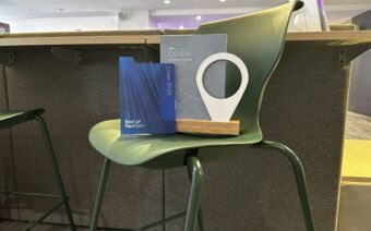 A green chair with a book on it and a blue plaque.