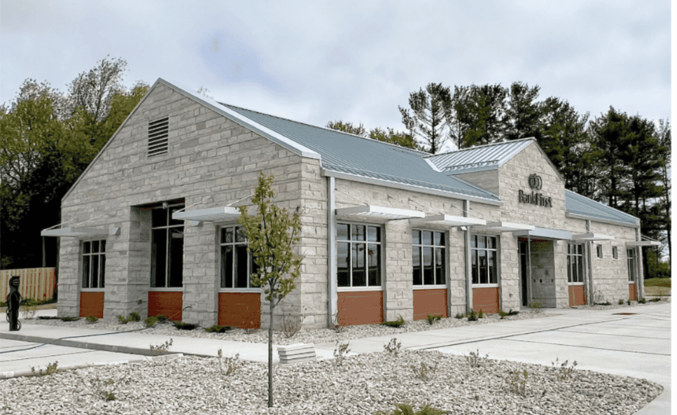 A building with a large stone facade and a large parking lot.