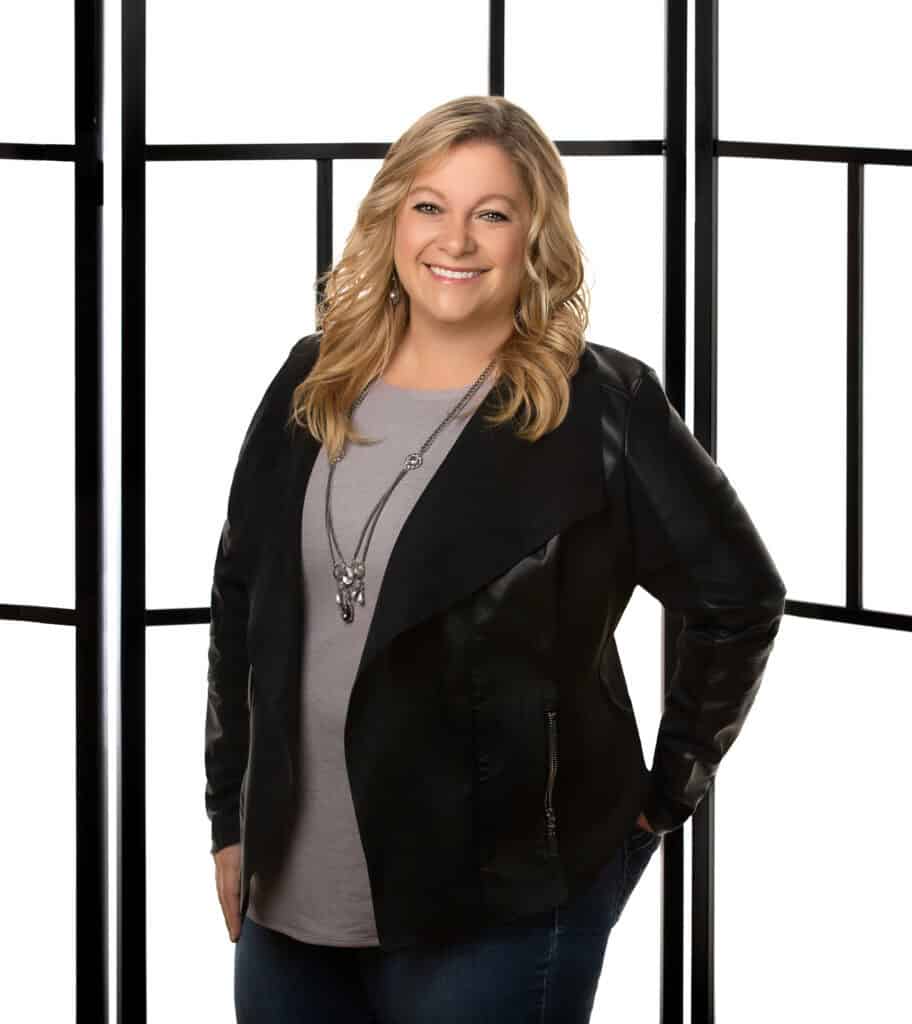 A woman in a black jacket and jeans.