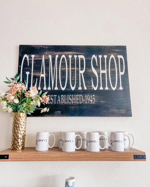 A sign that says glamour shop on a shelf.