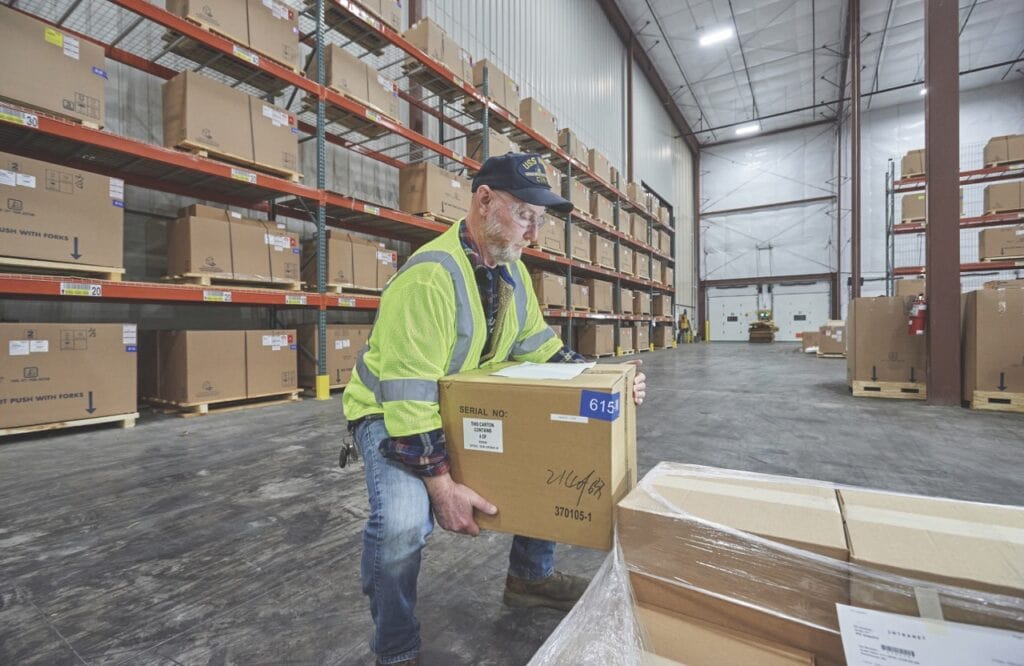 A man lifting a box in a warehouse.
