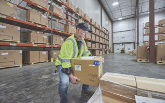 A man lifting a box in a warehouse.