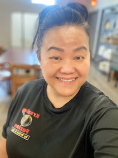 A woman in a black shirt smiling.