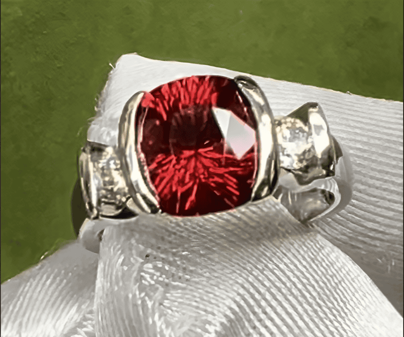 A red gemstone and diamond ring.