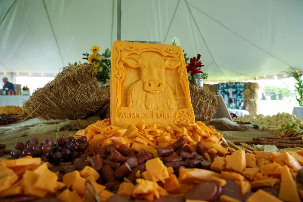 A large piece of cheese on a table with other food.