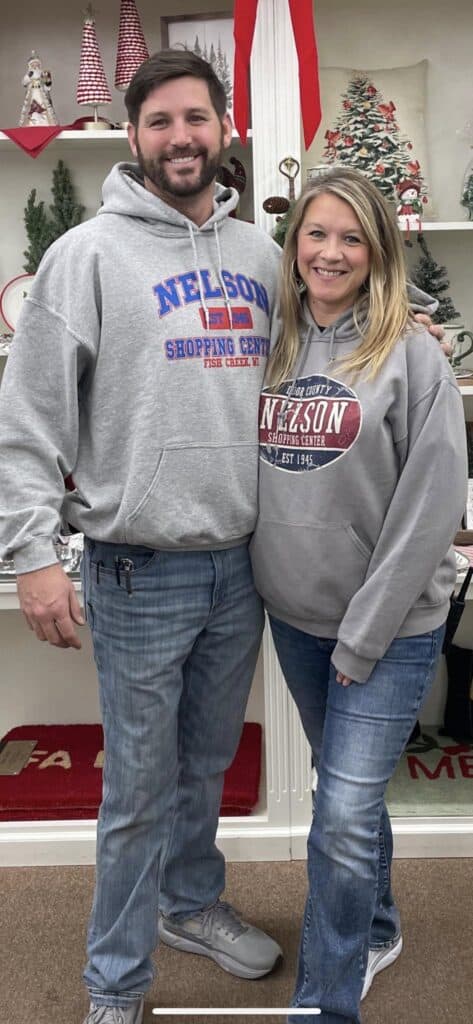 A man and woman wearing sweatshirts in a store.