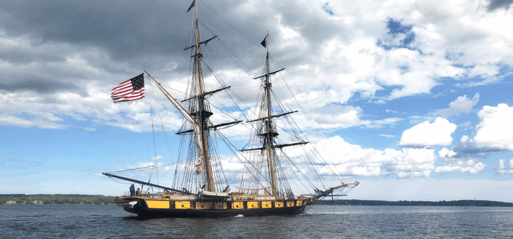 A tall ship with an american flag on the mast.