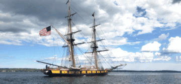 A tall ship with an american flag on the mast.