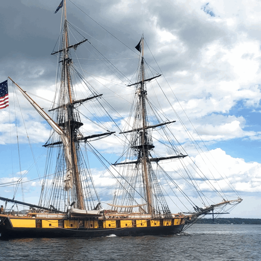 A tall ship with an american flag on the mast.